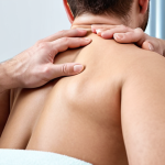 **A person receiving manual therapy on their neck and upper back from a skilled therapist, focused on soft tissue techniques. The setting is a modern, clean physiotherapy clinic.**
